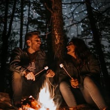 People roasting marshmallows over an outdoor campfire