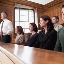 Jurors seated together while discussing a case in a courtroom.
