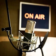 A podcaster recording audio into a microphone