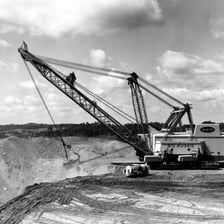 A large dragline excavator removing earth at an open-pit mine