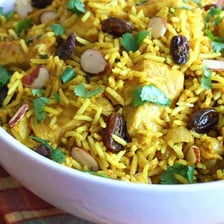 A serving of Indian biryani with spiced rice and pieces of chicken.
