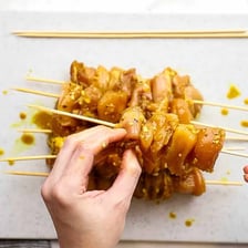Pieces of kebab or satay threaded onto a slender skewer