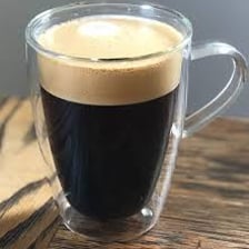 A cup of Americano coffee made with espresso and hot water.