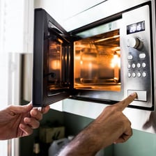 A container of food being warmed again in a microwave.
