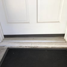 Close-up view of a doorsill at the bottom of a doorway beneath the threshold.
