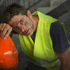 An exhausted worker struggling with a heavy load.