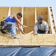 A house undergoing roof replacement with new roofing materials being installed.