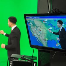 A meteorologist presenting a weather forecast beside a map