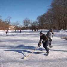 Players skating on a frozen pond.