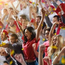 A passionate supporter cheering intensely at a sporting event.