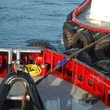 A tugboat pulling another vessel with a tow line