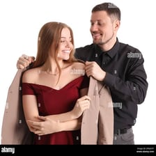 One person handing a coat to another person.
