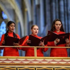 Several soprano singers performing as part of a choir.