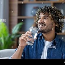 A person drinks water to quench their thirst.