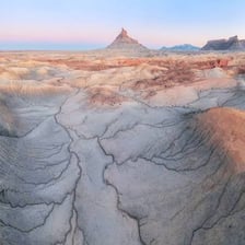 A barren badlands landscape with deeply eroded rock formations