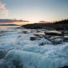 Rocky coastline and evergreen landscape in Acadia National Park, Maine.