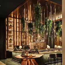 An upscale lounge has polished furnishings and decorative lighting.