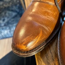 A leather shoe showing visible scuff marks and a dull rubbed area