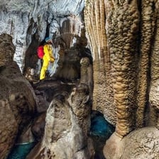 A person exploring the interior of a limestone cave