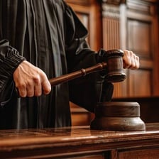 A judge holding a gavel in a courtroom.