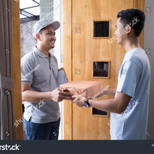 A person accepting a package from a delivery worker.