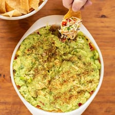 A bowl of guacamole served with tortilla chips.