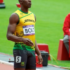 An athlete running at full speed during a short track race.