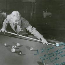 A skilled billiards player taking a shot in a pool hall.
