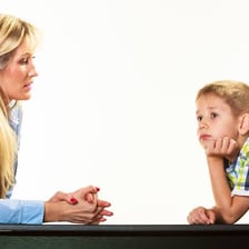 A child responding to an adult with a cheeky expression.