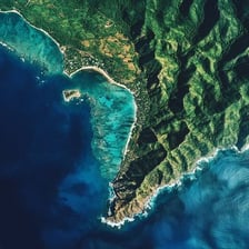 Aerial view of land bordering the sea.