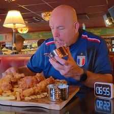 A person seated before an unusually large meal