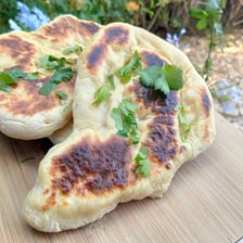 A round, baked naan flatbread served with an Indian meal.