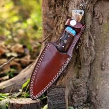 A hunting knife being inserted into a protective sheath