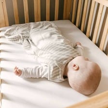 A restless infant moving around in a crib
