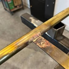 A close-up of a brass-colored joint on a decorative metal object.