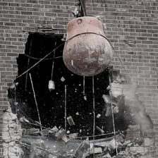 A wrecking ball breaking apart a building during demolition