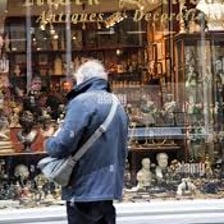 A shopper examining old objects in an antique shop.
