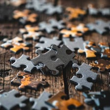 Puzzle pieces scattered and mixed together on a table.