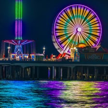 A large Ferris wheel carrying passenger gondolas at an amusement park.