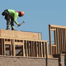 Construction workers wearing safety gear at a building site.