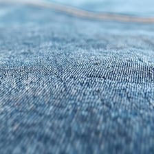 A close-up view of the woven texture of blue denim fabric