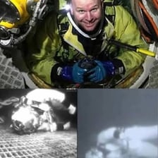 A diver underwater connected to support by a long umbilical hose.