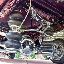 A customized lowrider car with a lowered suspension.