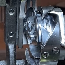 A hand freeing a small mechanical device from a blockage