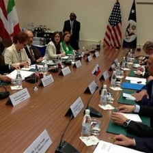 Two groups of people conducting a negotiation across a conference table