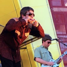Liam and Noel Gallagher performing with the band Oasis