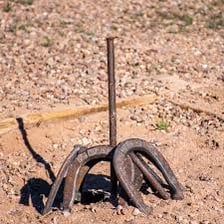 A horseshoe resting around a stake after a successful toss