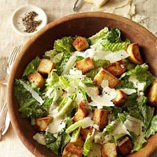 A Caesar salad with romaine lettuce, croutons, Parmesan, and dressing