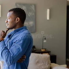 A person pausing thoughtfully while looking out of a window.