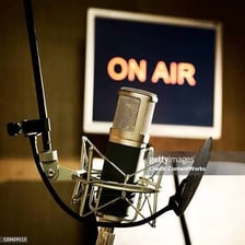 A radio studio microphone beside an on-air indicator